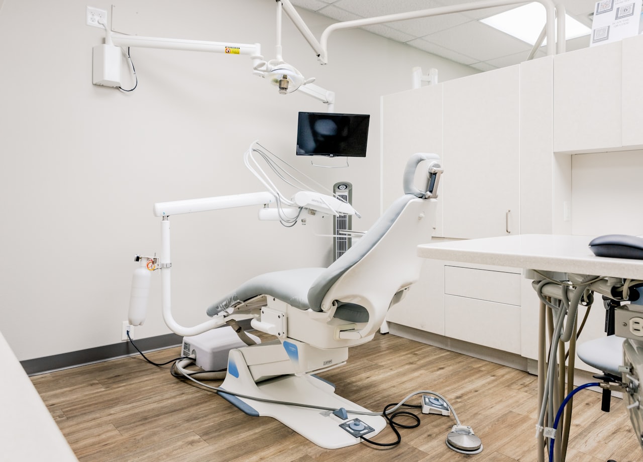 A clean, modern dental treatment room with chair and equipment